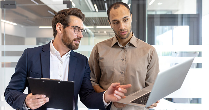 Two men with laptops in an office
