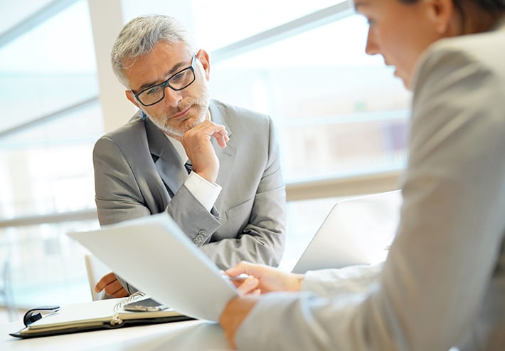 Woman showing business paper to man