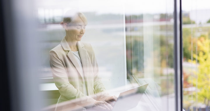 Frau arbeitet im Büro am PC