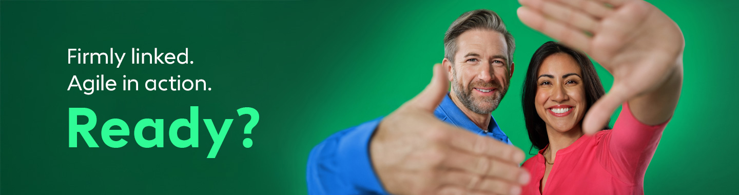 Two people smile at the camera and extend their hands invitingly.