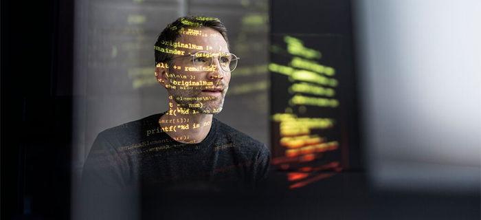 IT-Mitarbeiter bedient einen Screen mit dem Code.