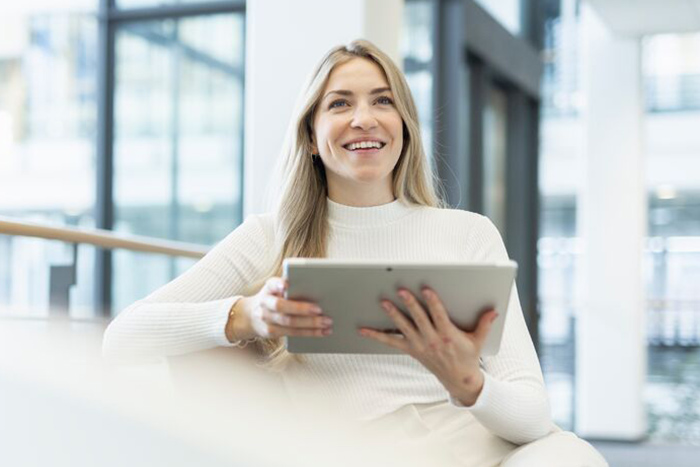 Freundliche Frau arbeitet am Tablet