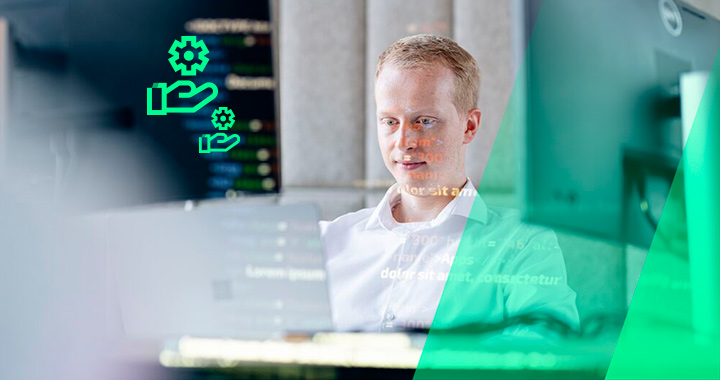Junger Mann arbeitet sitzend vor einem PC.