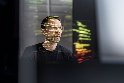 IT-Mitarbeiter bedient einen Screen mit dem Code.